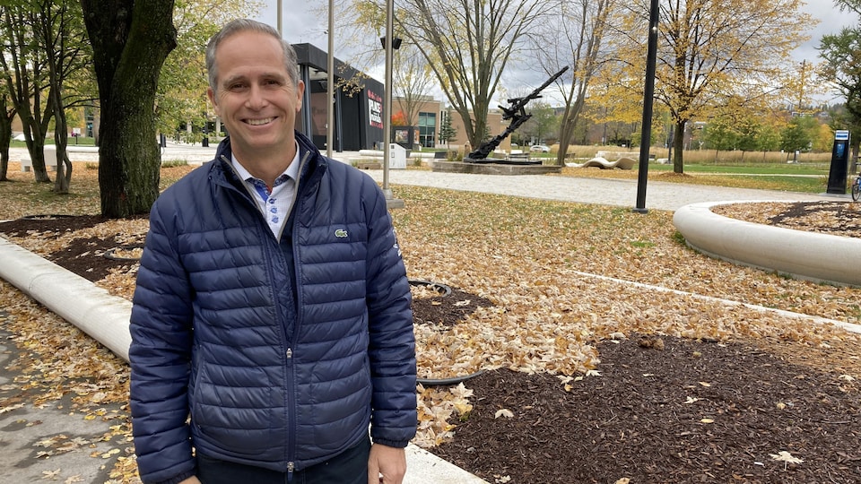 Dominic Gagnon est devant la place du Citoyen, à l'automne.