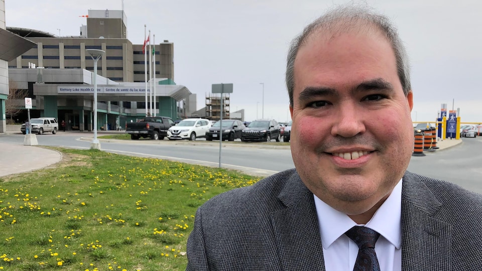 Dominic Giroux est tout sourire devant le Centre de santé du lac Ramsey. 