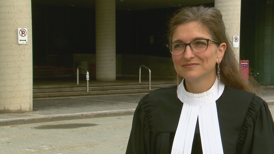L'avocate porte sa toge devant le palais de justice de Québec.