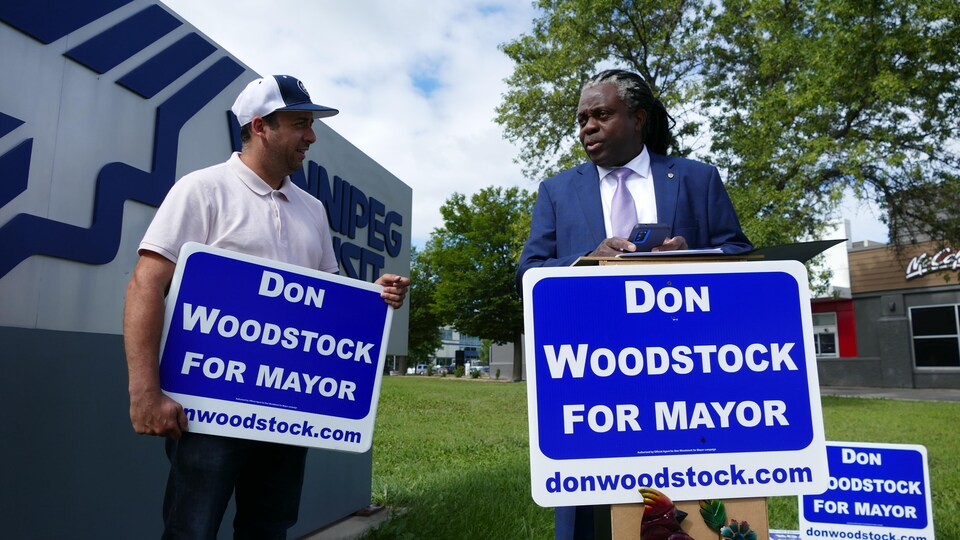 Don Woodstock (à droite) donne une conférence de presse à côté des garages de la Winnipeg Transit, le 3 août 2022. 