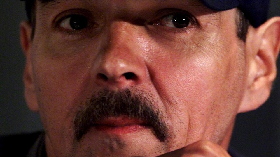 Donald Marshall pensif, coiffé d'une casquette de baseball.