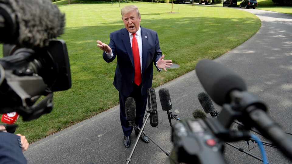 Le président Donald Trump s'exprime face à plusieurs micros.