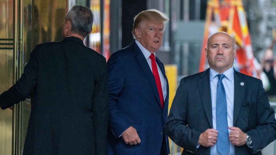 Donald Trump accompagné de deux gardes du corps.