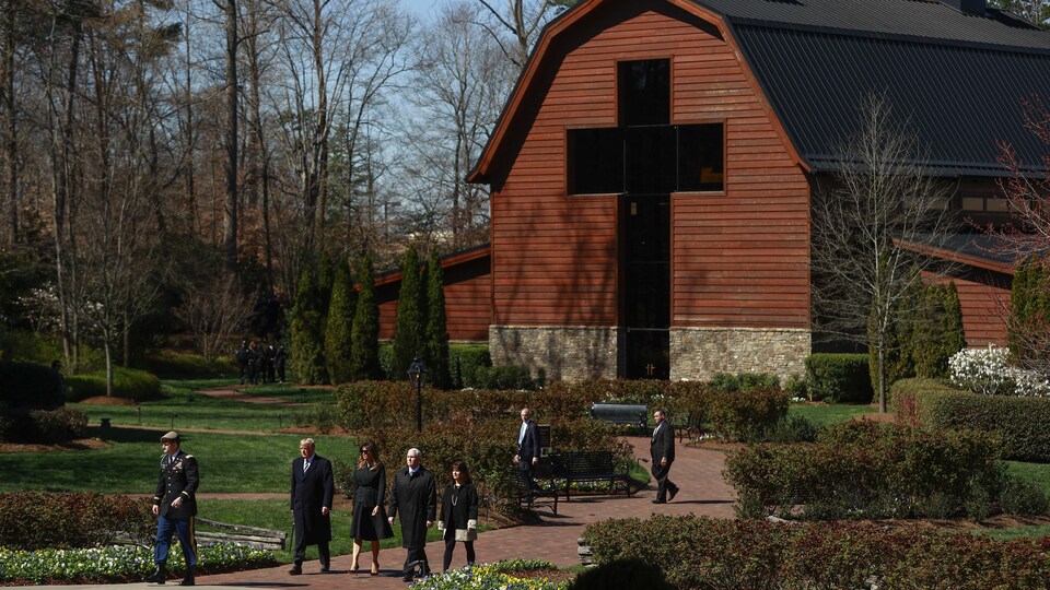 Donald Trump, sa femme et le vice-président Pence marchent devant un immense bâtiment dont toute la façade porte une croix.