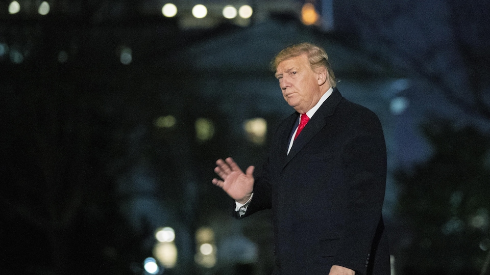 Donald Trump marche, l'air sérieux.