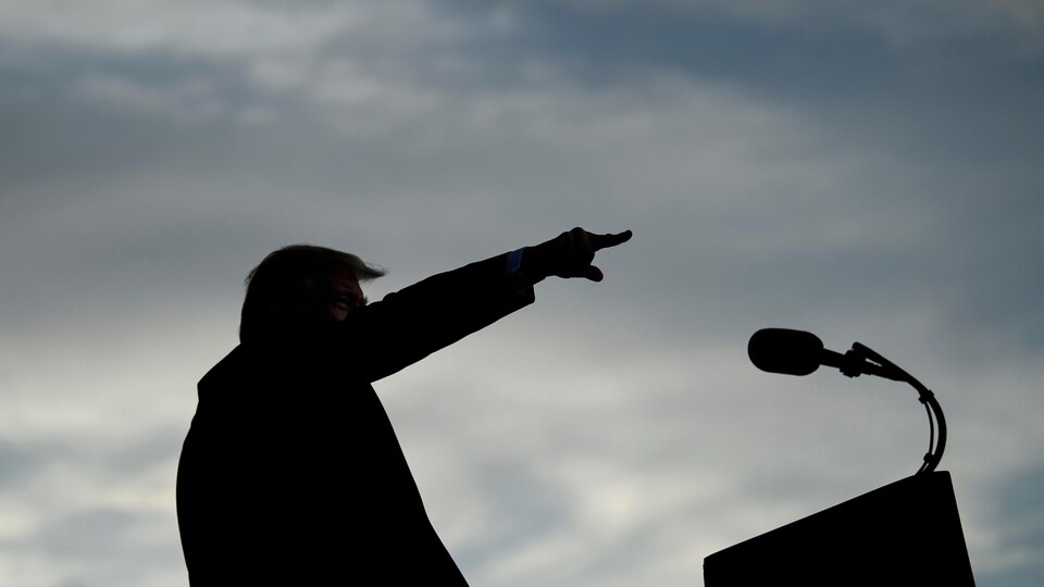 Donald Trump, à un lutrin, pointe droit devant.