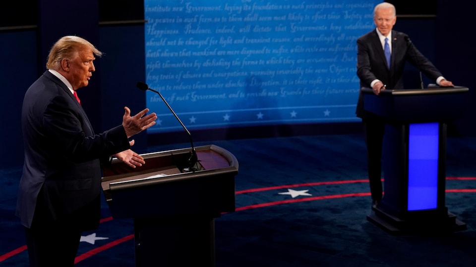 Donald Trump parle lors d'un débat et Joe Biden l'écoute.