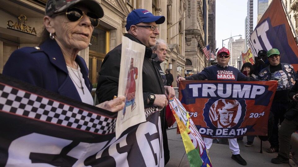 Des manifestants brandissent des pancartes en faveur à Donald Trump.
