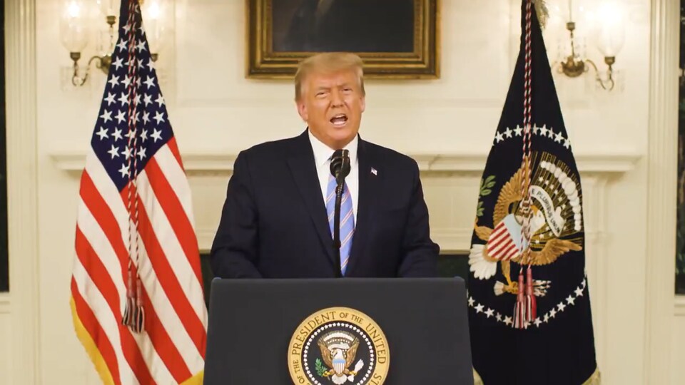 Donald Trump, derrière un lutrin, parle dans un micro.