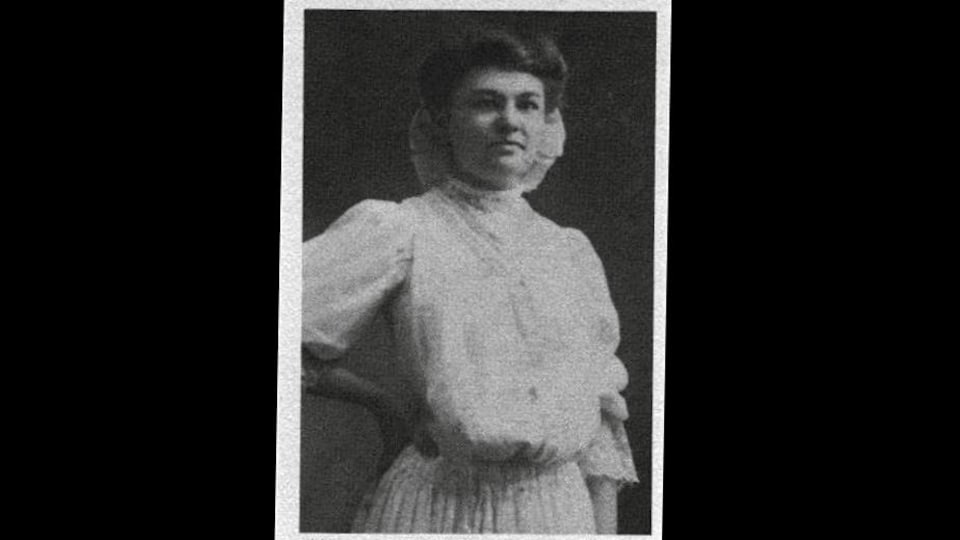 Photographie en noir et blanc de Donalda Charron, posant en robe claire à la caméra.