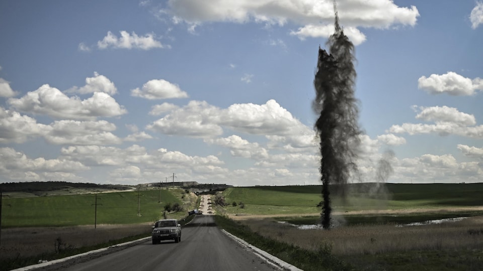 The impact of the shell lifted a large layer of land less than 10 meters from a car on a country road.