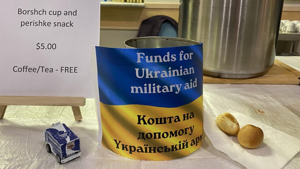 Il y a une boîte pour recueillir des dons sur un kiosque ainsi que des Perishke, des petits pains ukrainiens fourrés aux choux.  