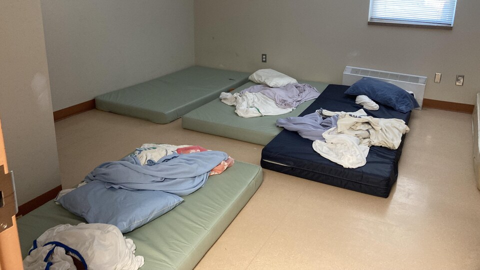 Quatre matelas sur le sol ayant des draps et des oreillers entassés dessus.