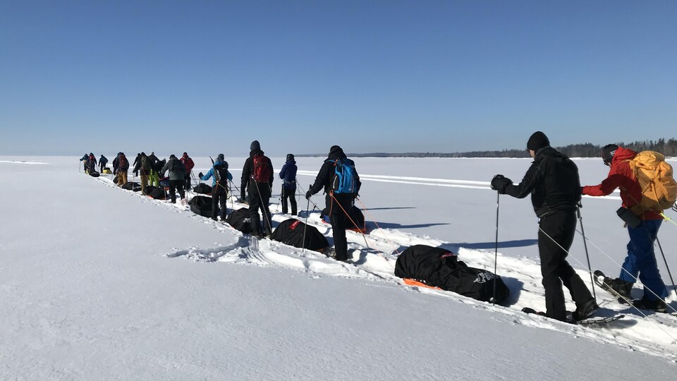 Des participants s'élancent en raquettes et en ski sur le lac Saint-Jean.