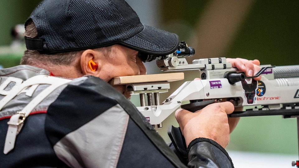 Un homme qui regarde dans son viseur de carabine lors d'une compétition.
