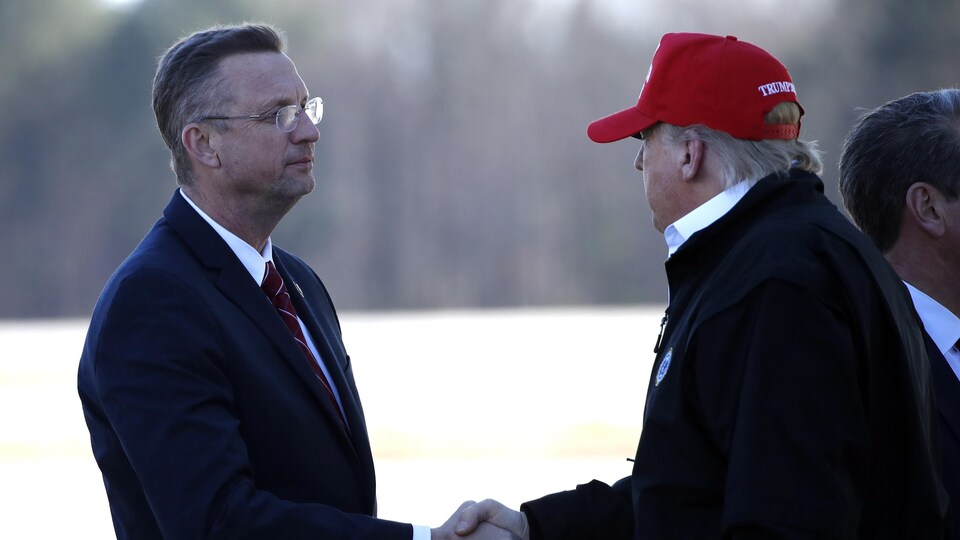 Le président Donald Trump accueille Doug Collins en lui serrant la main à son arrivée à la base de réserve aérienne de Dobbins à Marietta, en Georgie.