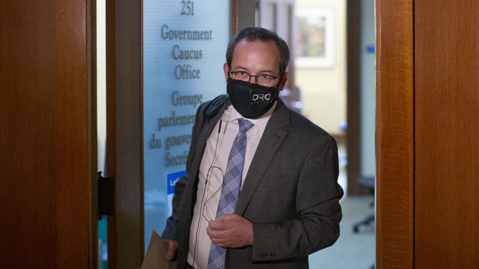Le procureur général de l'Ontario, Doug Downey, quitte son bureau sous les projecteurs des caméras.
