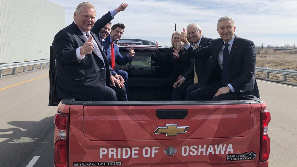 Doug Ford takes his place with other dignitaries inside a pickup truck.