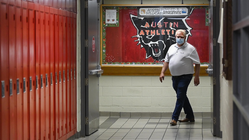 Le premier ministre Doug Ford marche dans le couloir de l'École secondaire catholique Father Leo J Austin de Whitby. 