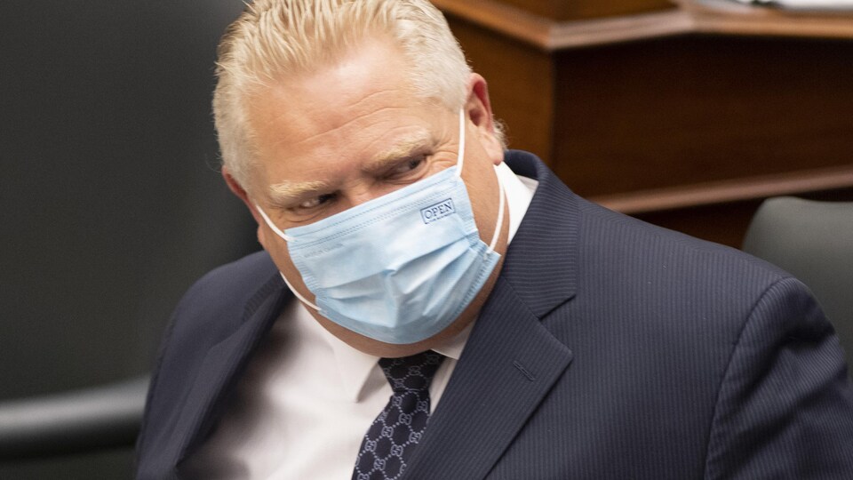Doug Ford à l'Assemblée législative portant un masque.
