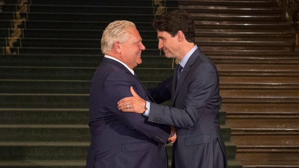 Doug Ford et Justin Trudeau se serrent la main.
