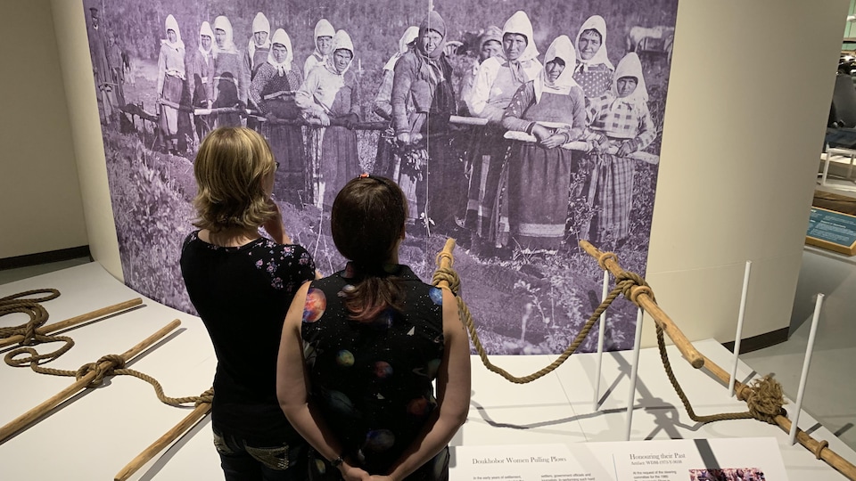 Deux visiteurs regardent l’exposition The Doukhobor Living Book Project: 120 Years in Saskatchewan au Western Devloppement Museum de Saskatoon.