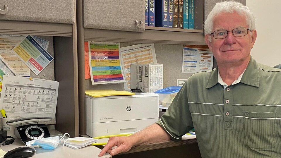 Le médecin prend la pose pour une photo dans son bureau.