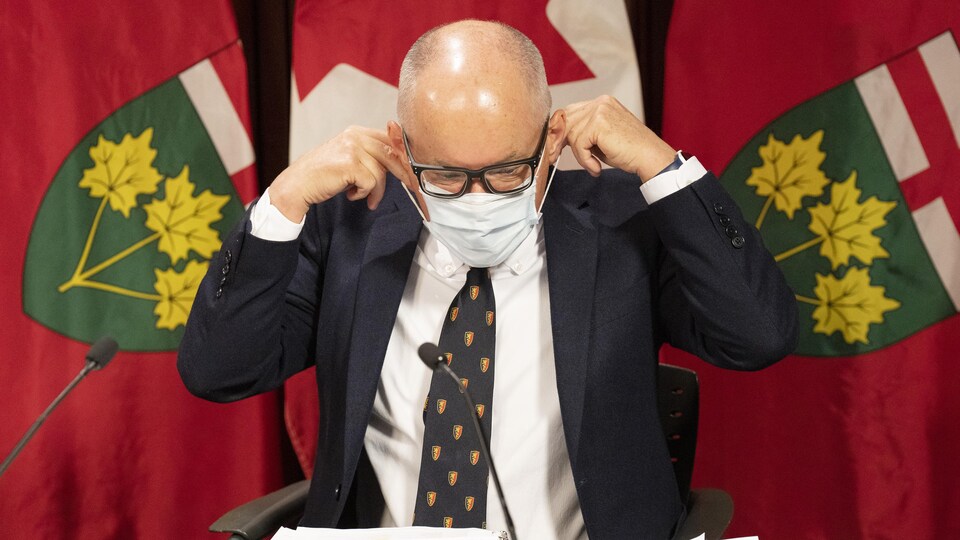 Le Dr Kieran Moore enlève son masque avant le début d'une conférence de presse à Queen's Park le 14 novembre 2022.