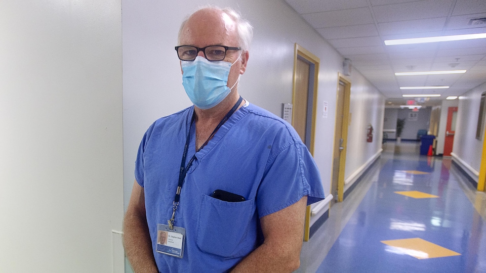 Un médecin portant un masque dans un couloir d'hôpital.