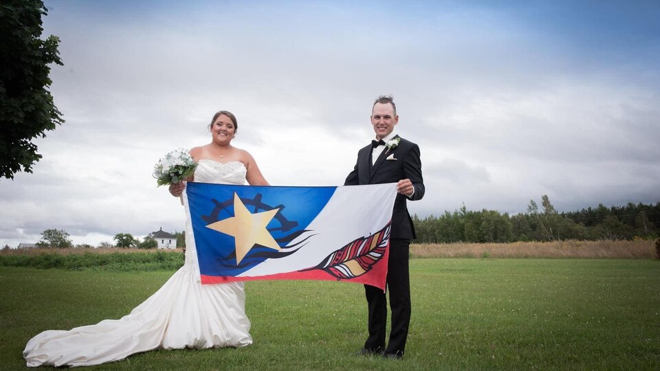Dominique Gould et son mari tiennent le drapeau.