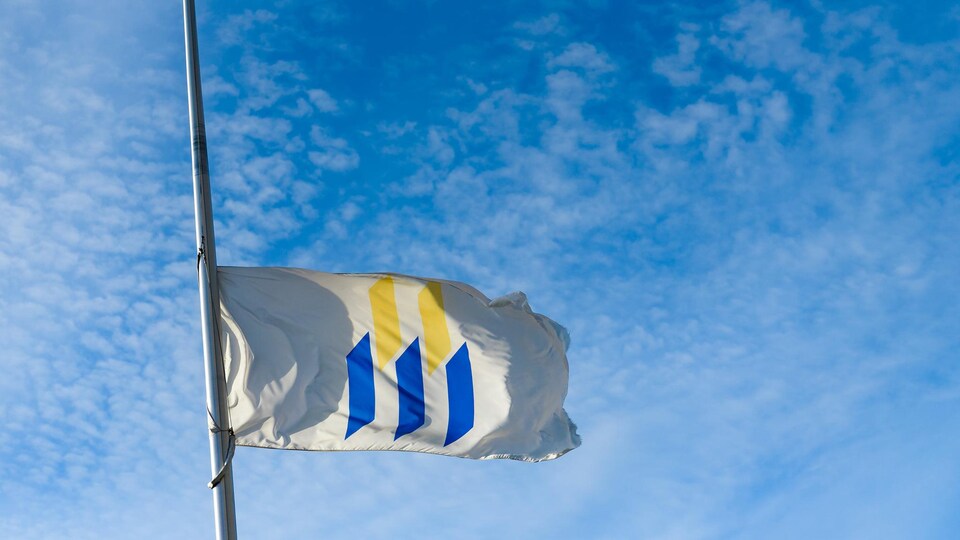 Le drapeau de l'Université de Moncton en berne.
