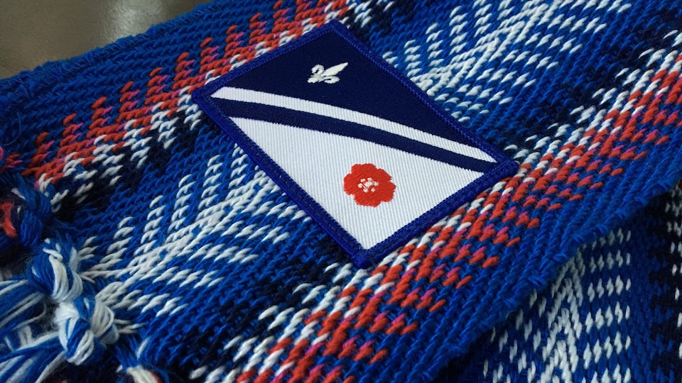 Le drapeau franco-albertain brodé sur une ceinture fléchée