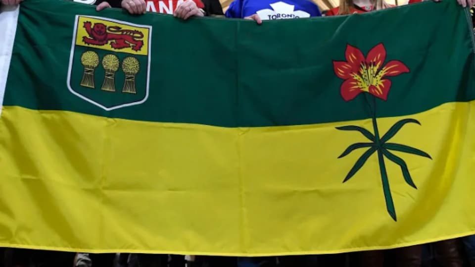 Un drapeau de la Saskatchewan, tenu par des habitants de la province.