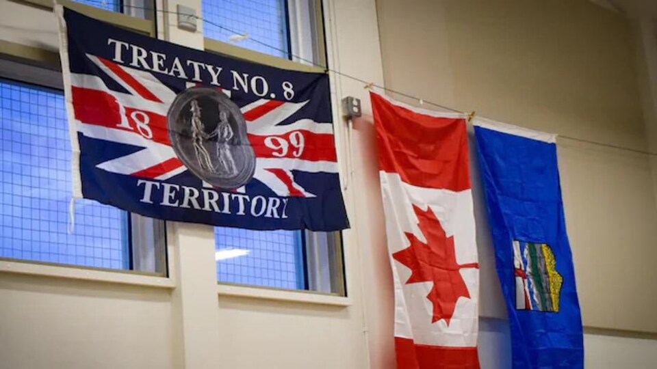 On voit le drapeau du Traité no 8 sur un mur, à côté de celui du Canada et de celui de l'Alberta.