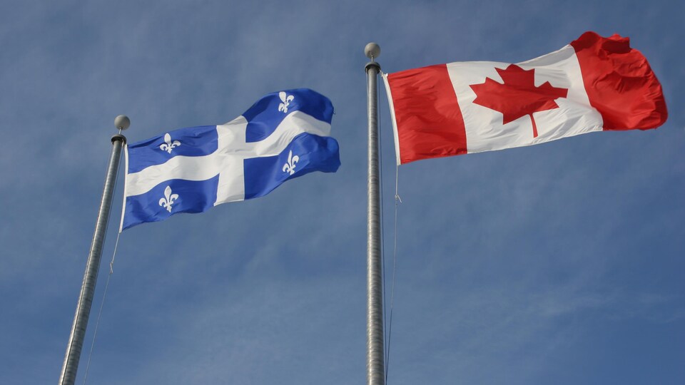 Les drapeaux du Canada et du Québec, côte à côte.