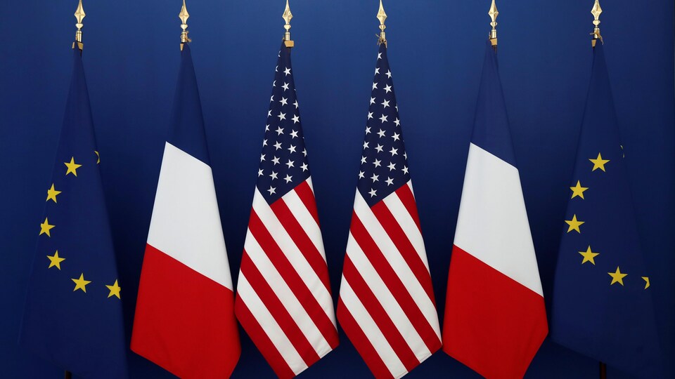 Des drapeaux de l'Union européenne, de la France et des États-Unis.