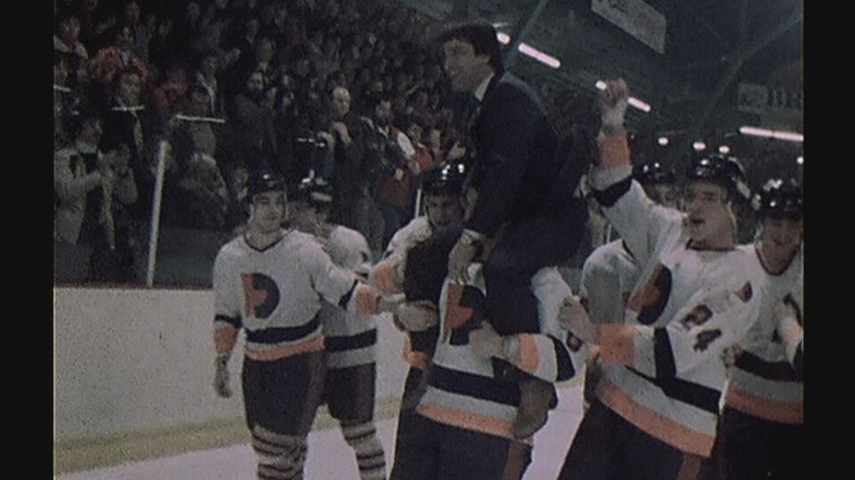 Un joueur porte Michel Bergeron, l'équipe et les partisans célèbrent.