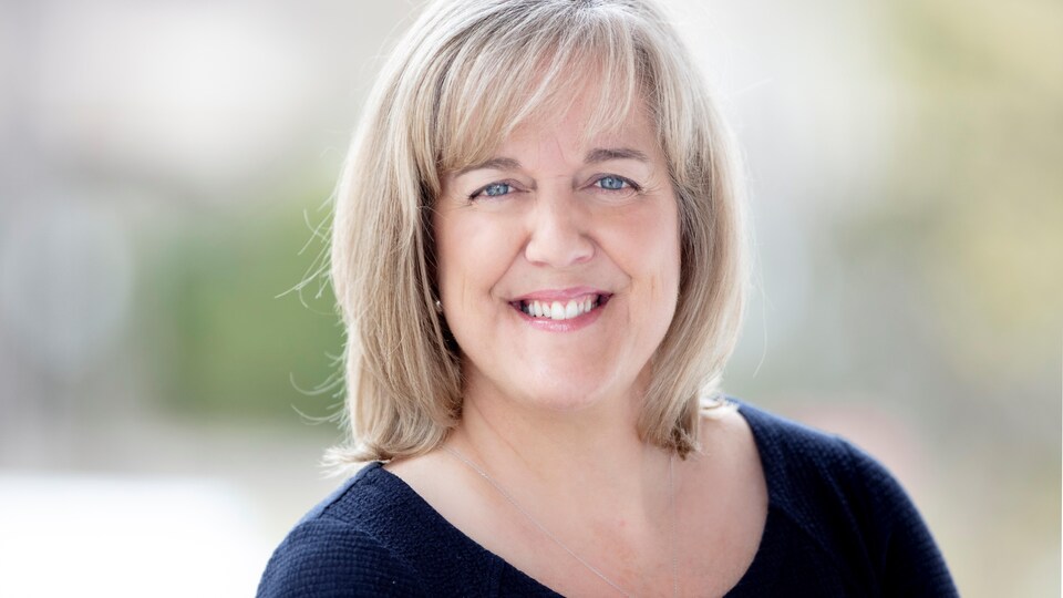 Le portrait d'une femme souriante.