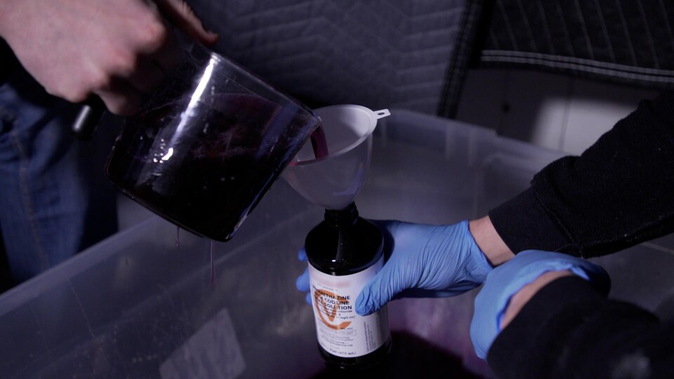 Deux producteurs de sirop de codéine frelaté en versent dans une bouteille. 