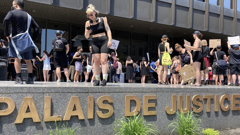 Des manifestantes brandissent des pancartes devant le palais de justice de Montréal en signe d'appui au droit à l'avortement.