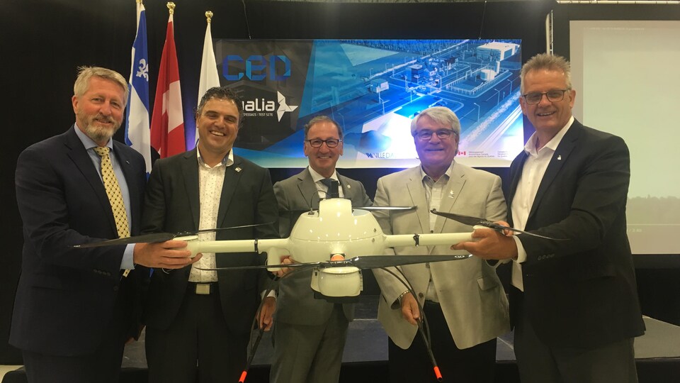 Marc Moffat, le directeur du centre d'excellence des drones d'Alma, en compagnie des élus régionaux. 