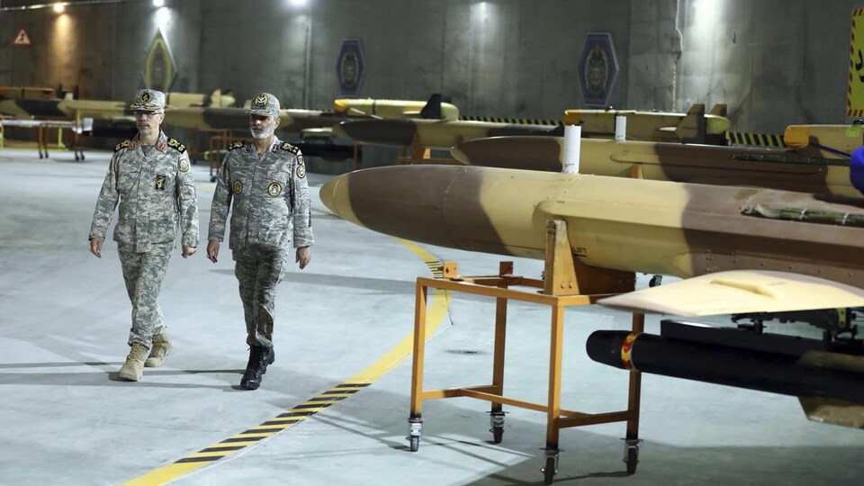 Deux hommes marchent au milieu de ce qui semble être des drones. 