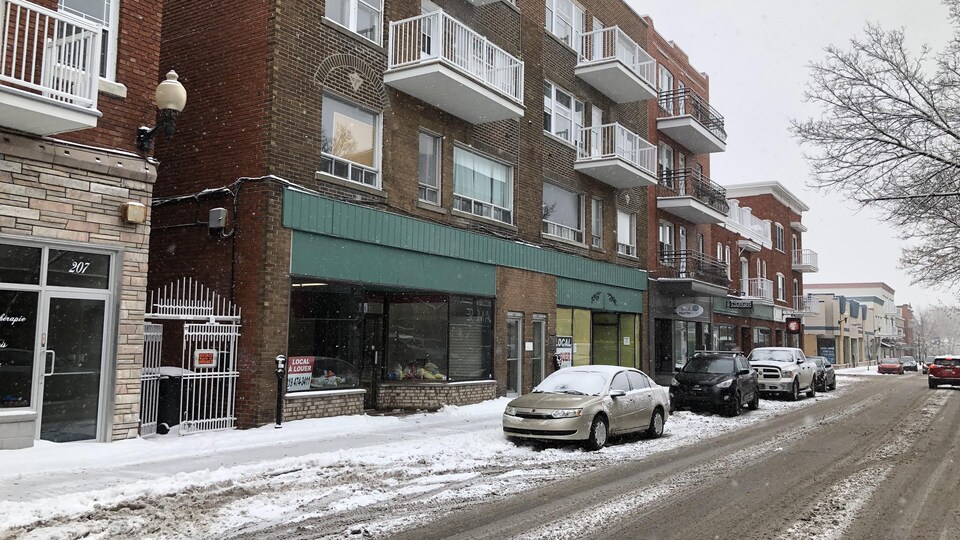 Des voitures stationnées devant un immeuble de Drummondville.