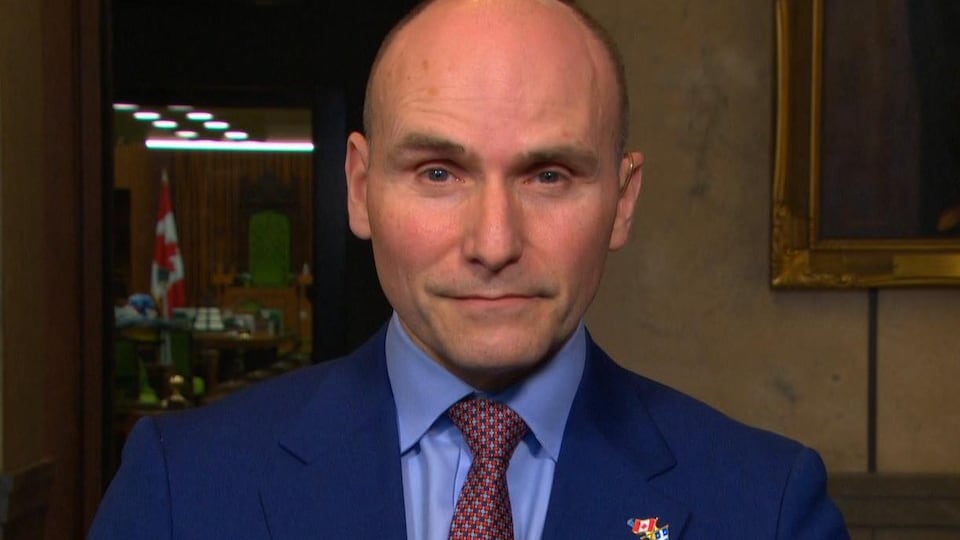 M. Duclos regardant droit dans la caméra.