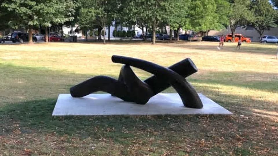 Une sculpture imagée d'une homme en train de se prélasser sur l'herbe.