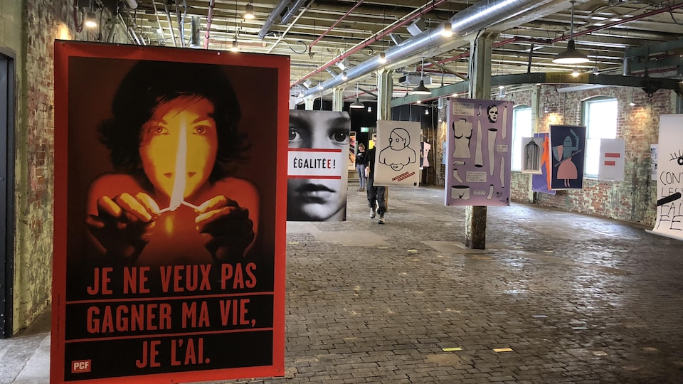 Des affiches féministes sont suspendues dans une ancienne usine.