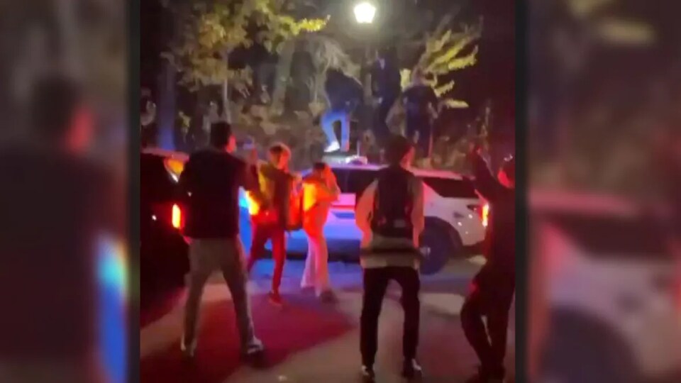 Des vidéos de la fête ont largement circulé sur les réseaux sociaux, certaines montrant des fêtards sautant sur le toit d'un véhicule de police lors d'une intervention à East St Paul, au Manitoba, le 29 octobre 2022.