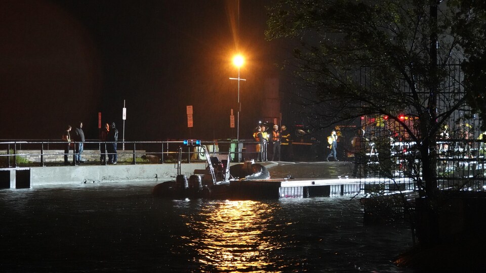 Lifeguards stood at the dock in the dark. 