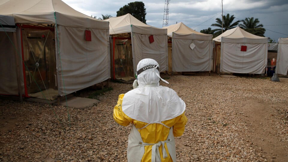 Un agent de santé en tenue de protection près d’unités de soins d'urgence
