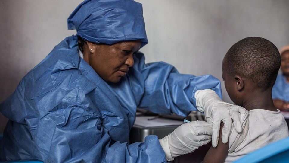 Une infirmière administre un vaccin à enfant.